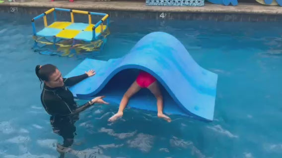 Foam pool waterslide in a swim lesson, instructor-assisted slides