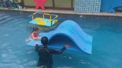 Foam pool waterslide in use at a swim school, kids climbing and sliding